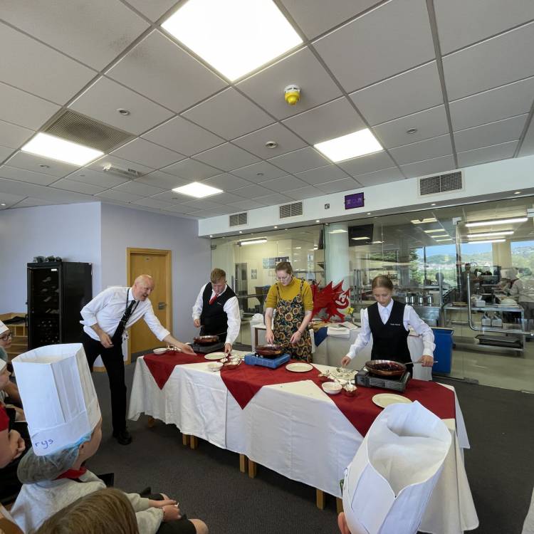 Coleg Llandrillo hospitality and catering students giving Year 5 and 6 pupils a flambé demonstration