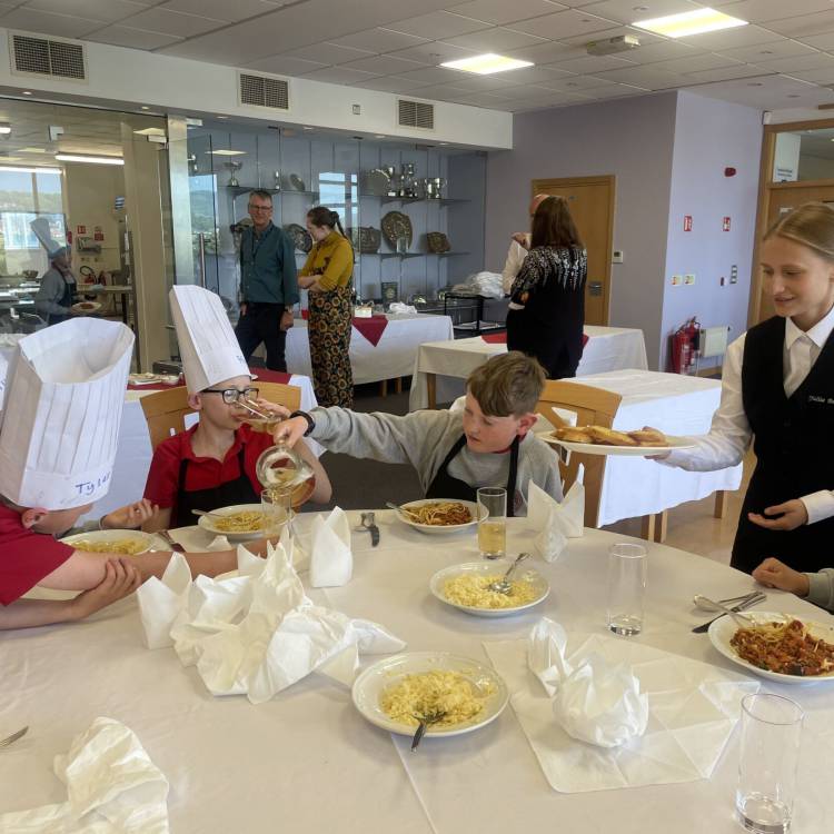 Children enjoying a Bolognese cooked by the class