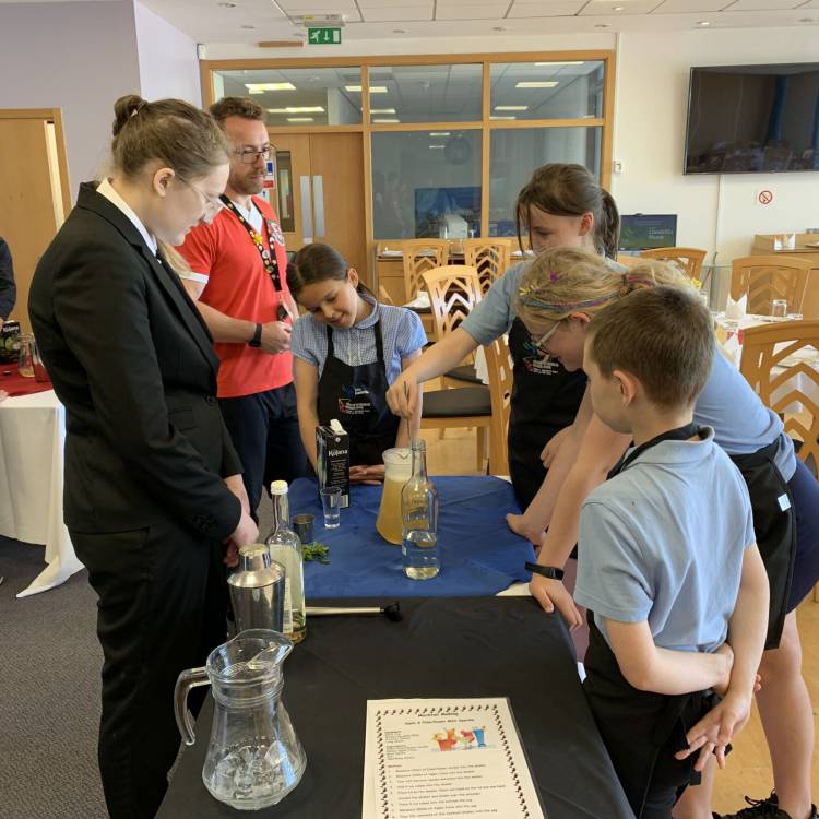 Primary school pupils learning how to mix non-alcoholic cocktails
