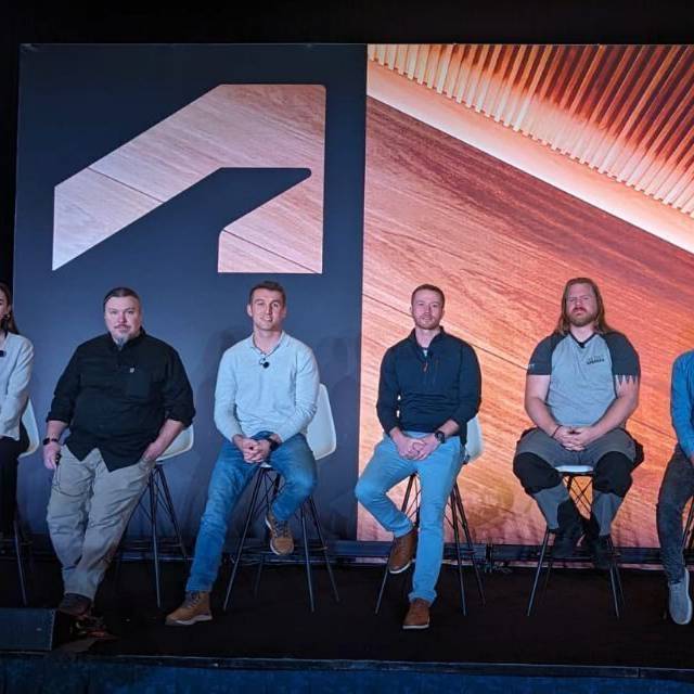 Iwan Roberts a Bryn Jones ar y llwyfan gyda'u cyd-siaradwyr yng Nghynhadledd Prifysgol Autodesk 2023