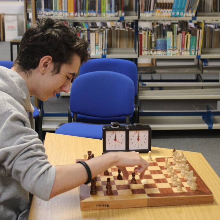 Myfyrwyr yn cymryd rhan mewn twrnamaint gwyddbwyll yn llyfrgell Coleg Llandrillo ar gampws Llandrillo-yn-Rhos