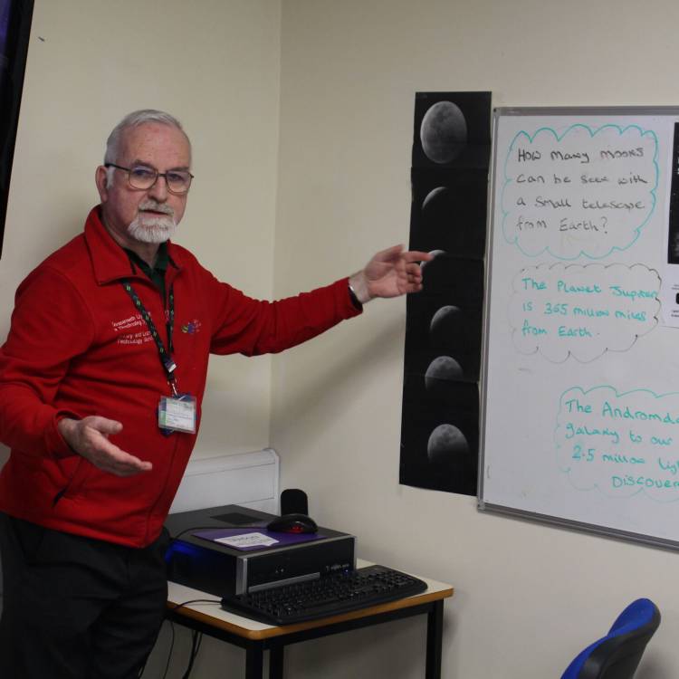 Brian Woosnam, cynorthwyydd o siop argraffu'r llyfrgell, yn cyflwyno darlith ar seryddiaeth