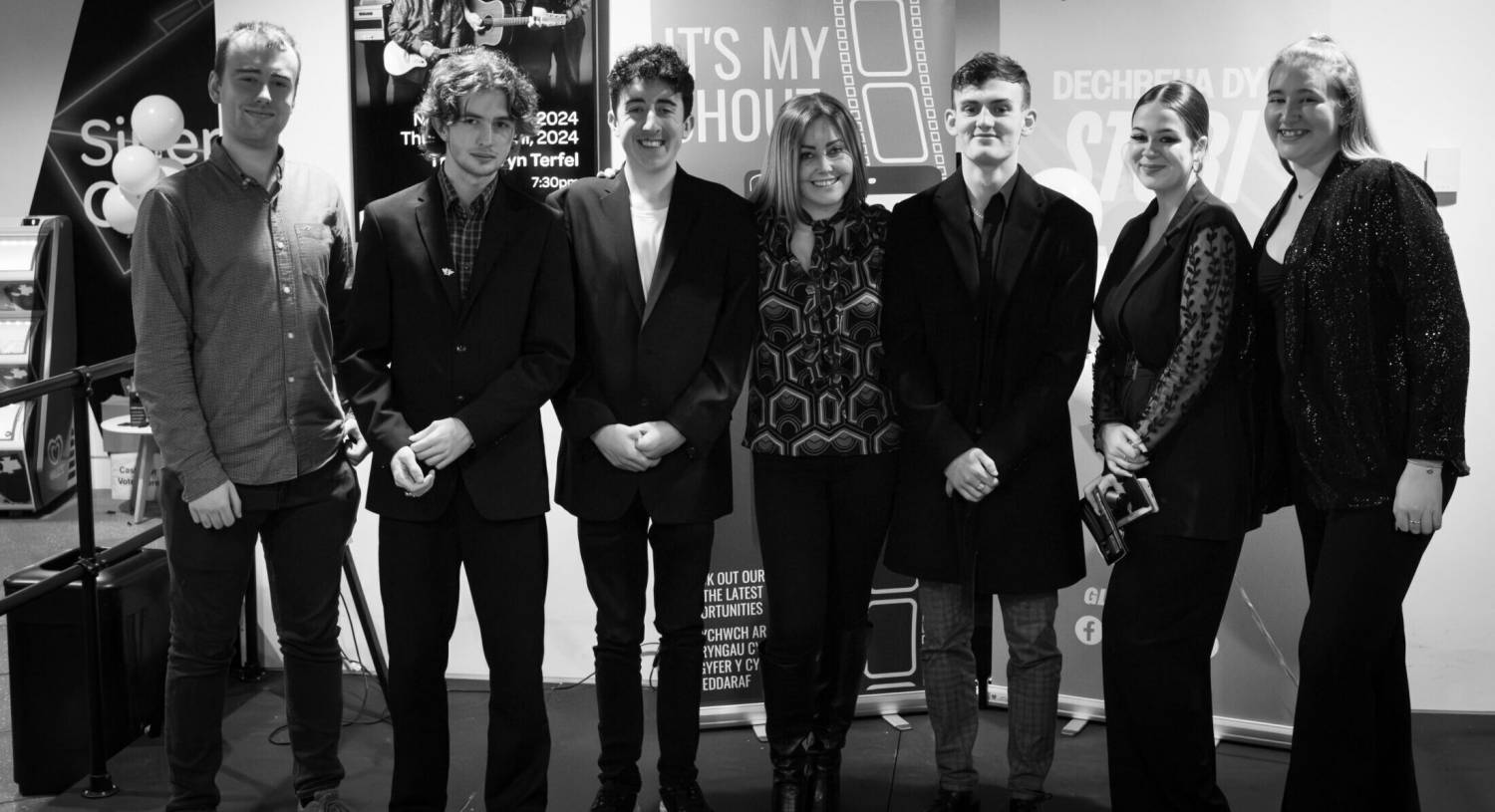 Myfyrwyr Coleg Menai gyda chyfarwyddwr The Hunger Pang Gang Ceri Bostock ym mherfformiad cyntaf It's My Shout 2023 yn Pontio, Bangor
