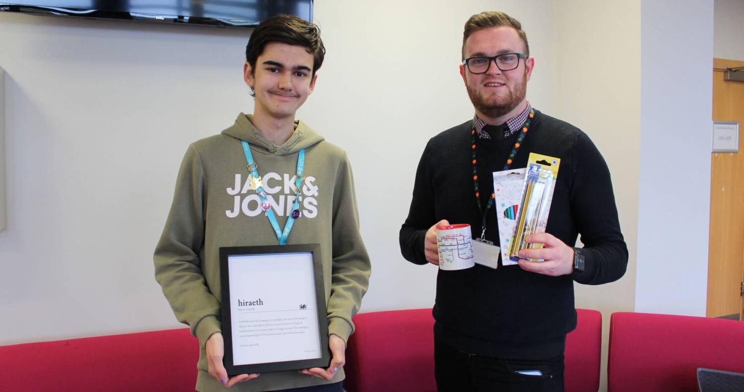 Tom Roberts yn derbyn ei wobr gan Samuel Stones, un o Hwyluswyr y Gymraeg yng Ngrŵp Llandrillo Menai
