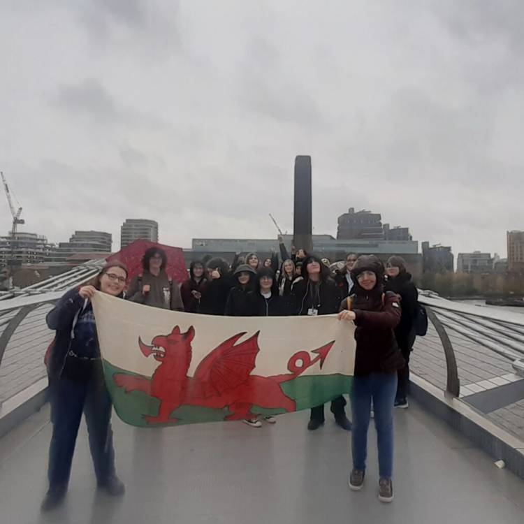 Myfyrwyr Coleg Meirion-Dwyfor ar Millennium Bridge yn Llundain, gyda'r Tate Modern yn y cefndir