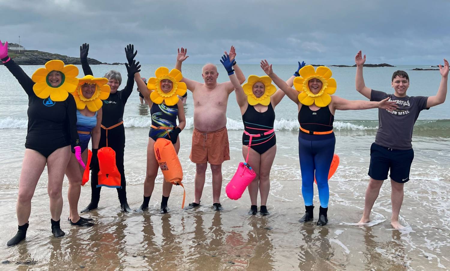 Criw o bobl ar draeth Bae Trearddur ar ôl nofio yn y môr yn ystod sesiwn Lluosi