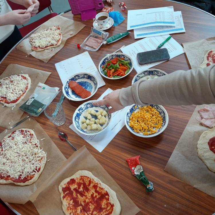 Pobl yn gwneud pizzas fel rhan o sesiwn Lluosi