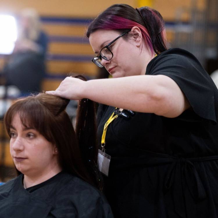 Myfyriwr o Goleg Llandrillo, Ceri Thomas, yn steilio gwallt yn rownd derfynol Dysgwr y Flwyddyn 2024 - Gwallt Cysyniadol